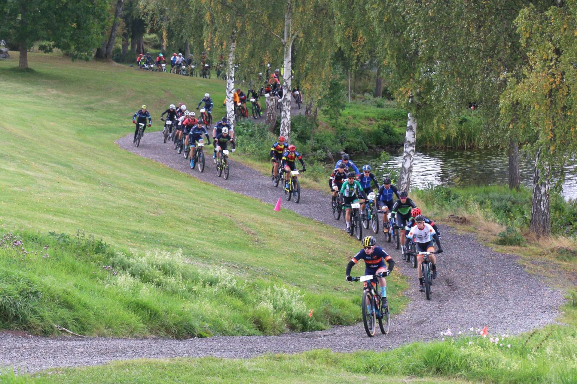 Starten har gått på långa banan och cyklisterna ger sig i väg på stigen längs Höljen.