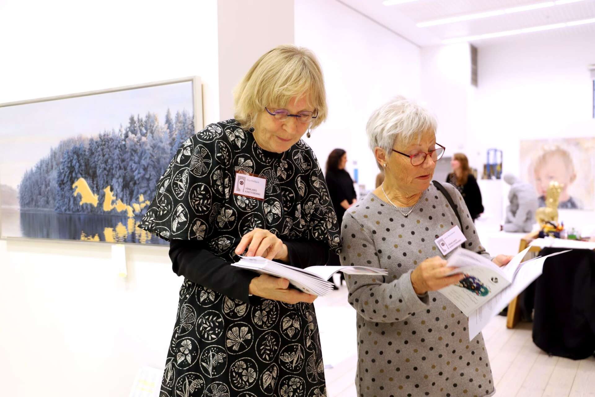 Elsa Hallbäck och Lena Bonnevier från Värmlands konstförening bläddrar i utställningskatalogen. Det är många namn att hålla reda på, i den stora salongen.