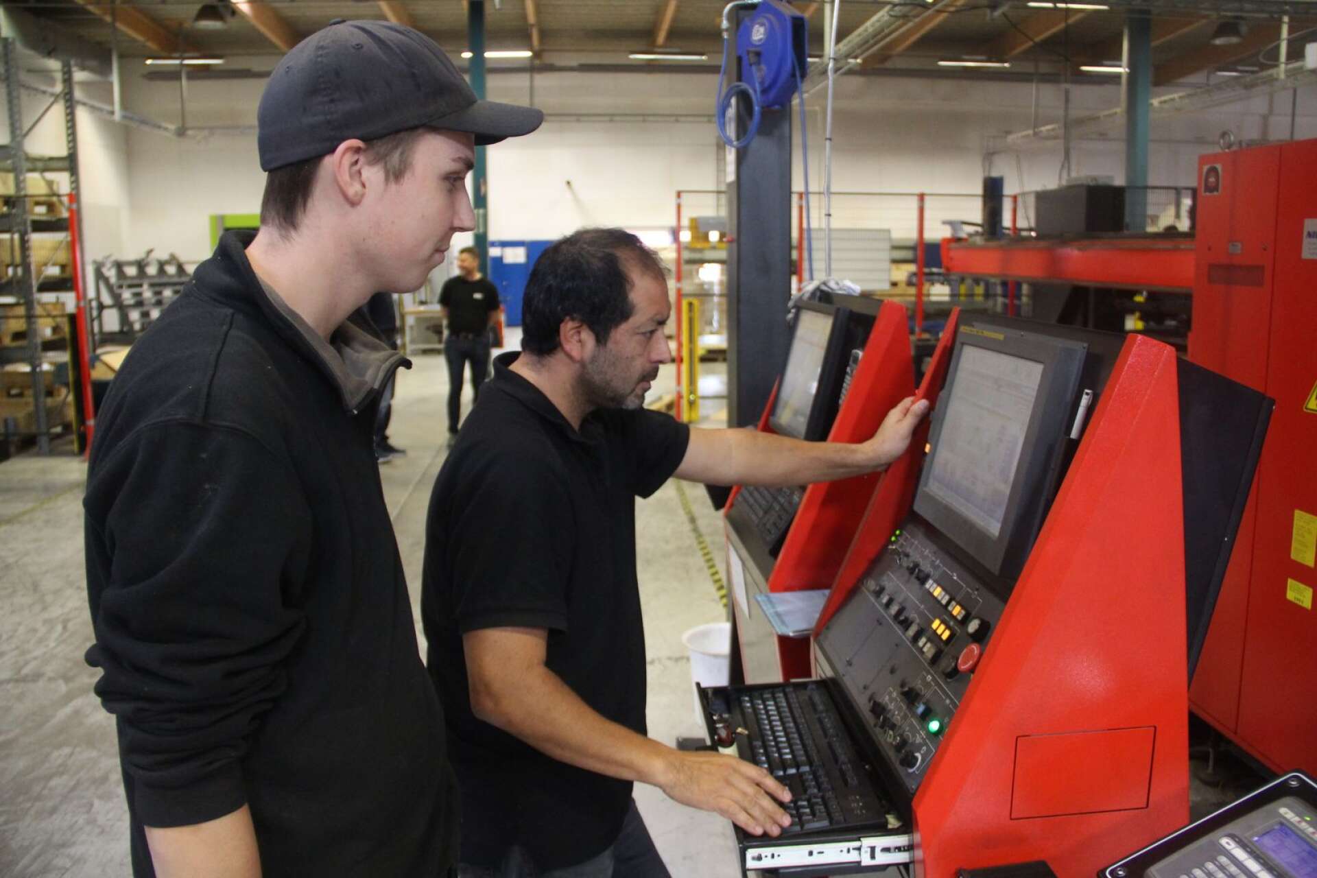 Erik Larsson och Fernando Tello programmerar en stansmaskin.