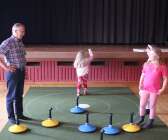 Bo Augustsson visade Lily och Emy Nielsen och Ella Lundberg hur mattcurling går till.