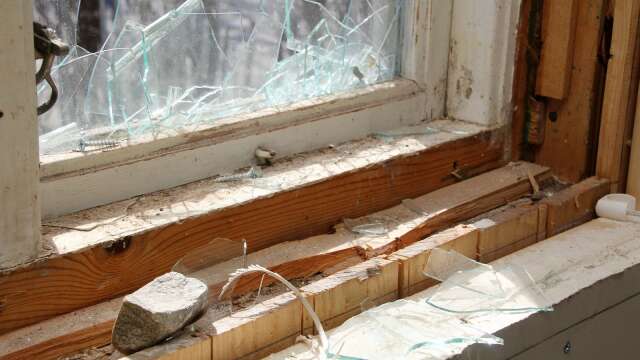 Innanför fönstret ligger en sten som har används till att krossa en av fönsterrutorna. 