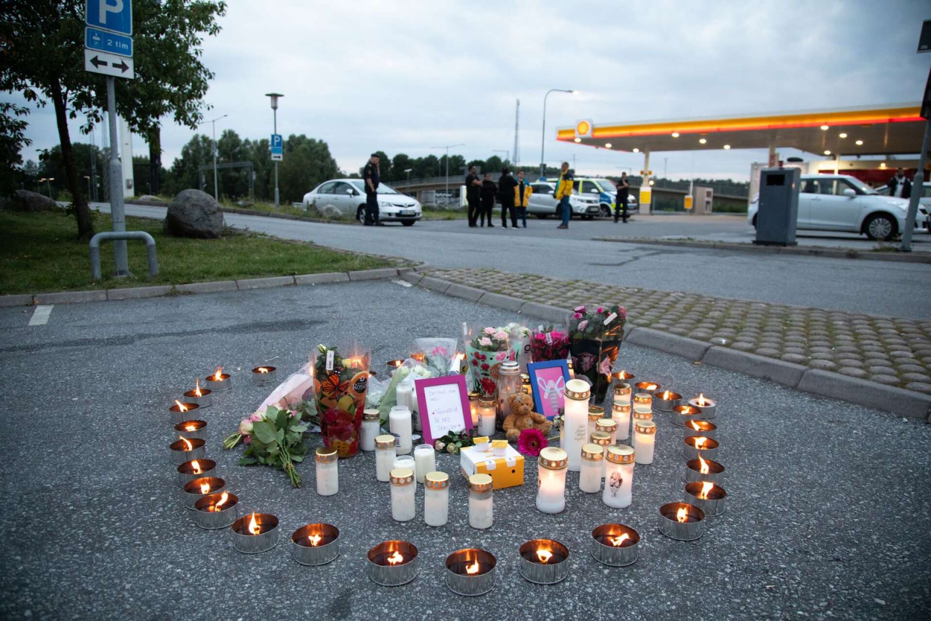 Blommor och ljus på platsen där en tolvårig flicka sköts ihjäl i Norsborg.
