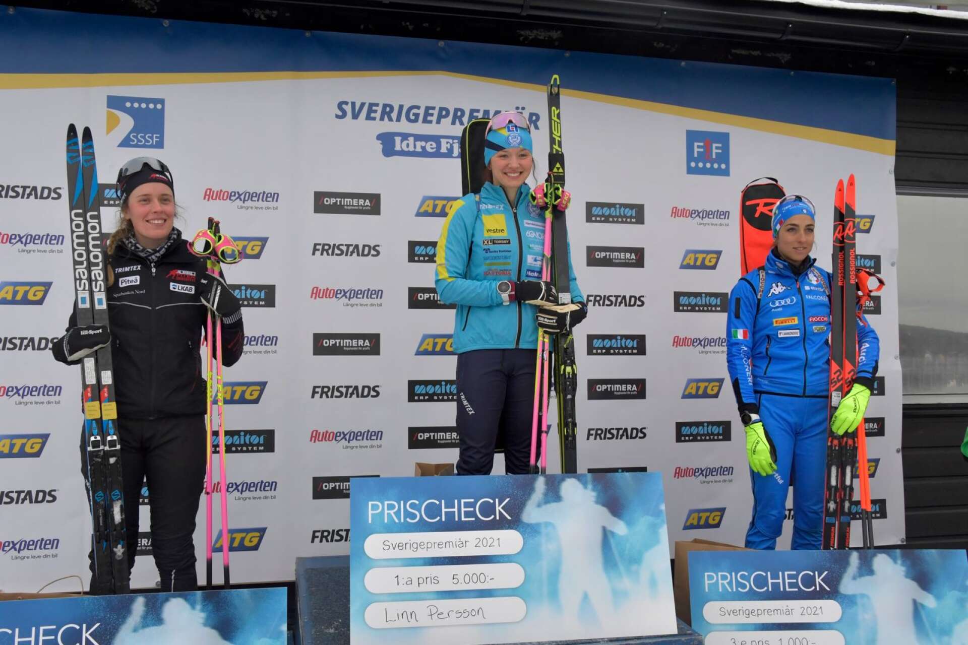 Linn Persson högst upp på prispallen, flankerad av tvåan Elvira Öberg och trean Lisa Vittozi.